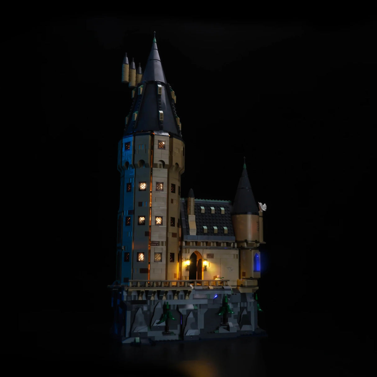 Beleuchtetes Lego Schloss Hogwarts mit hohen Türmen und vielen Fenstern auf schwarzem Hintergrund