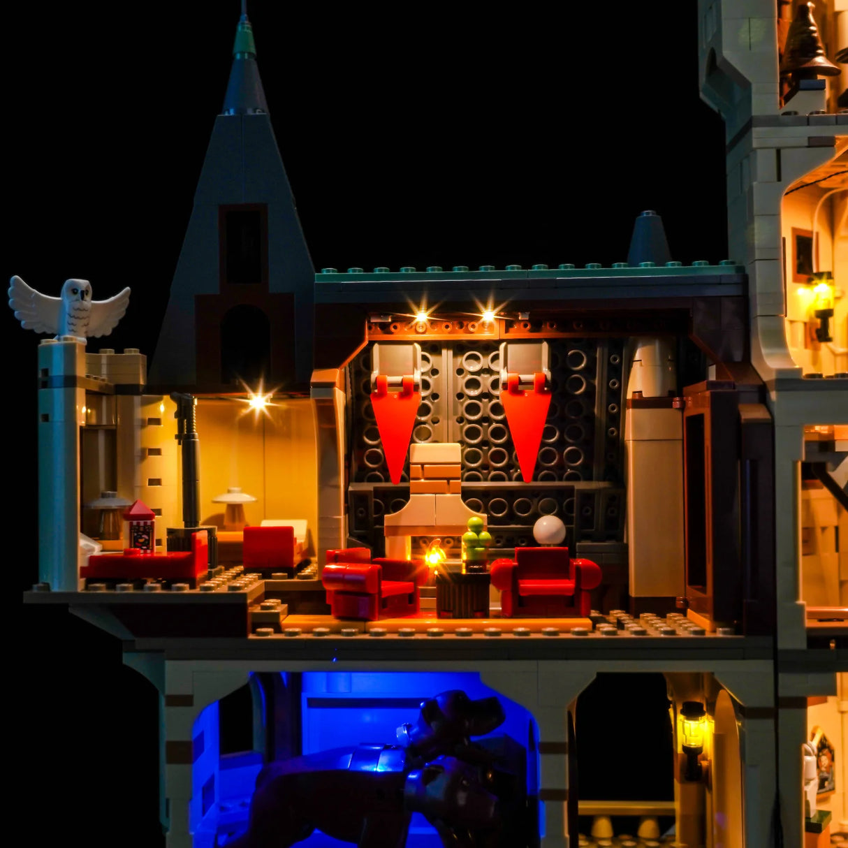 Beleuchtetes LEGO Schloss mit Eule, roten Stühlen und blauem Licht im unteren Bereich