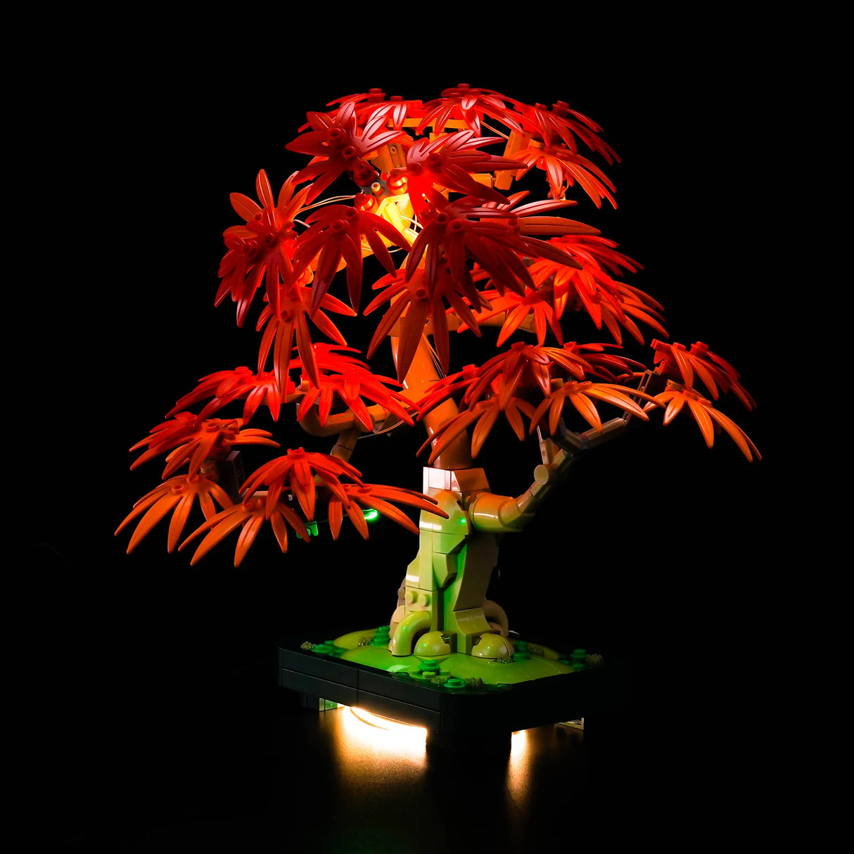 Beleuchteter LEGO Bonsai-Baum mit roten Blättern auf schwarzem Hintergrund