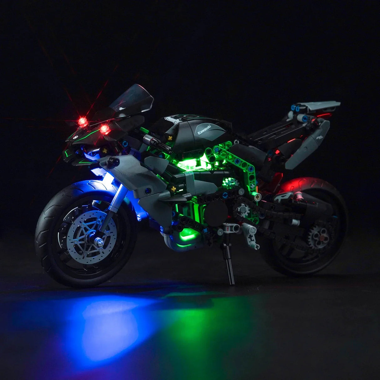 Modell eines Kawasaki Motorrads mit leuchtenden roten, grünen und blauen Lichtern auf schwarzem Hintergrund