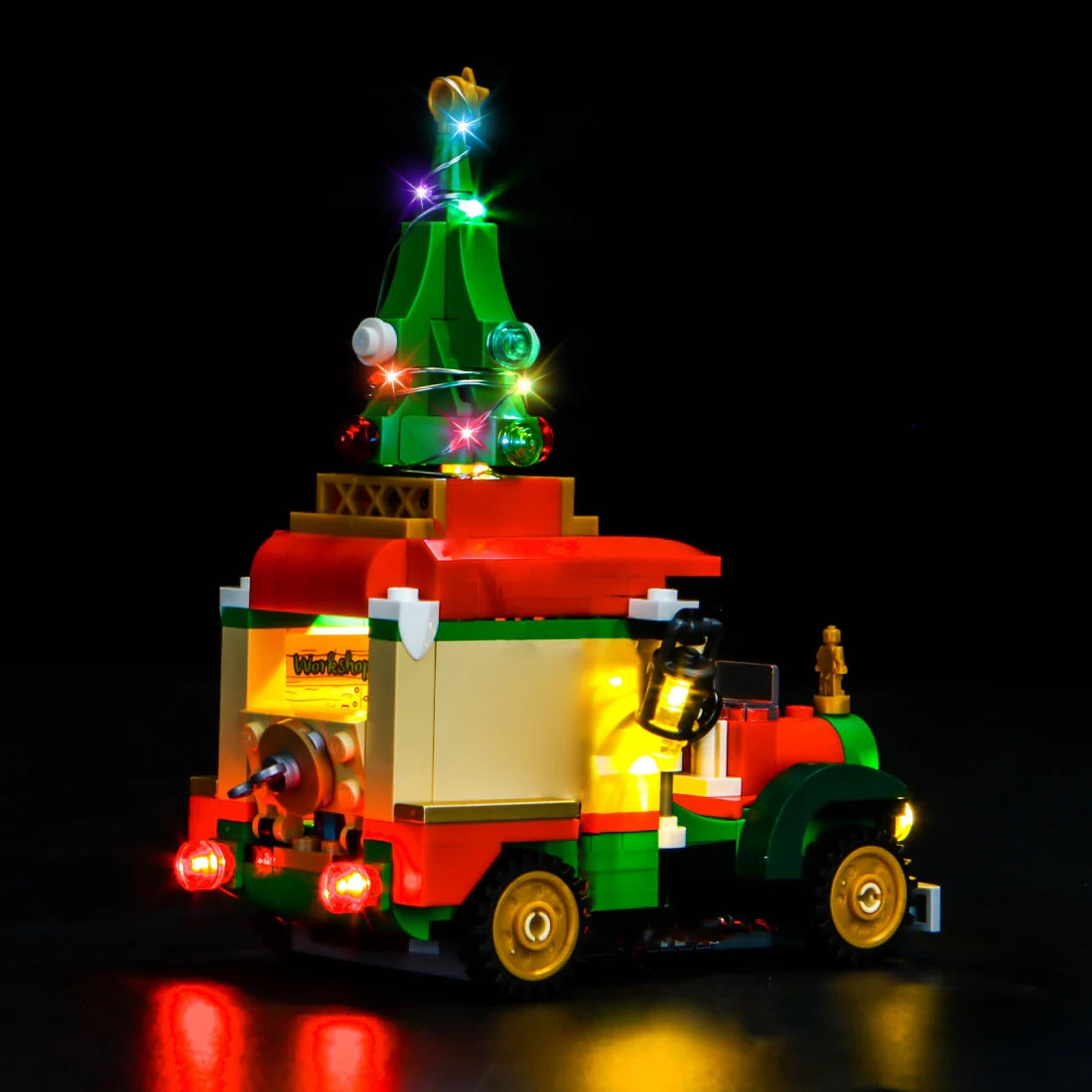 Beleuchtetes Lego Weihnachtsauto mit Tannenbaum auf dem Dach vor schwarzem Hintergrund