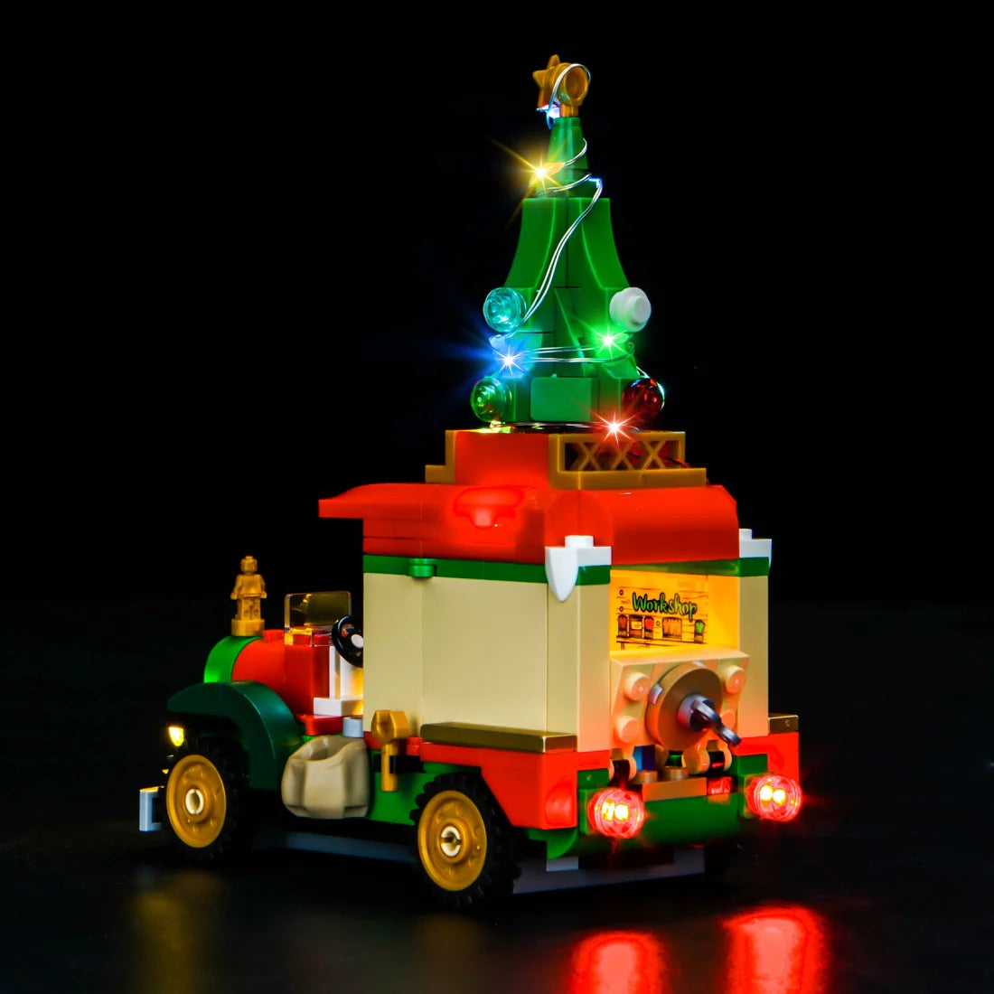 Beleuchtetes Lego Fahrzeug mit Weihnachtsbaum auf dem Dach vor schwarzem Hintergrund