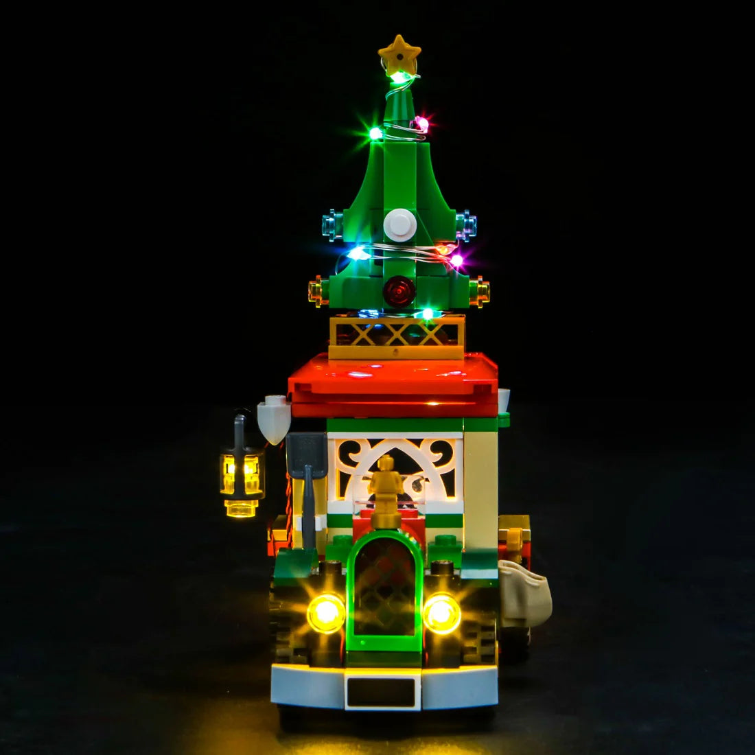 Beleuchtetes Lego Fahrzeug mit Weihnachtsbaum auf dem Dach vor schwarzem Hintergrund