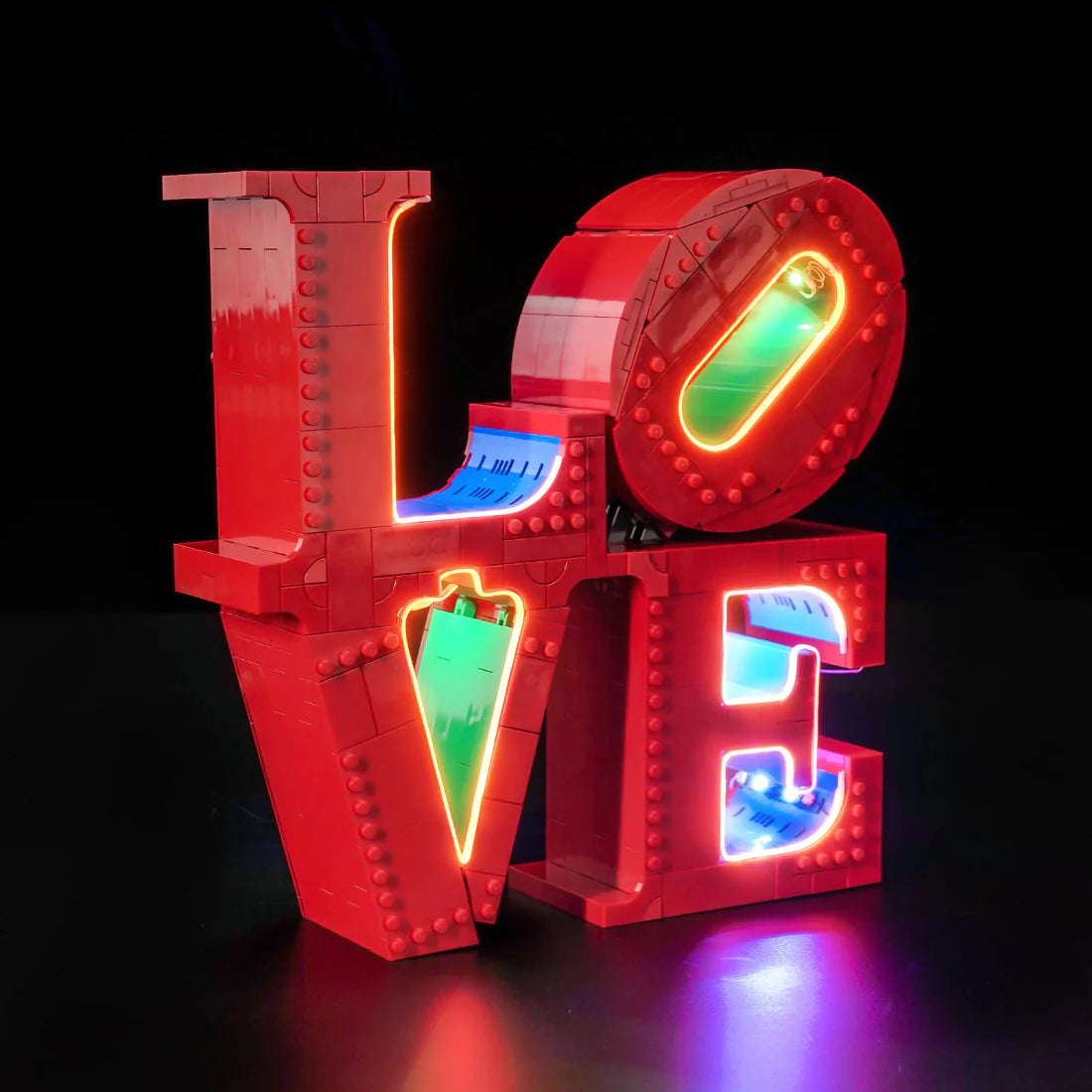 Rotes LEGO-Schild mit dem Wort LOVE, beleuchtet mit Neonlichtern in verschiedenen Farben
