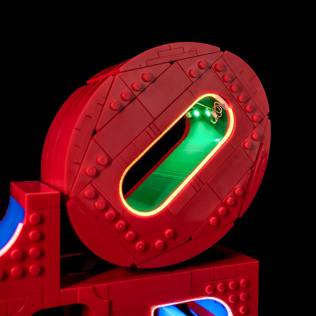 Nahaufnahme des beleuchteten LEGO Spider-Man Logos mit grünen und gelben Lichtern