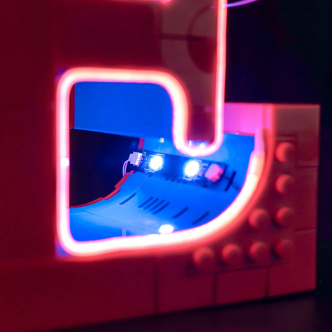 Nahaufnahme eines roten Lego-Modells mit leuchtenden blauen und roten Lichtern