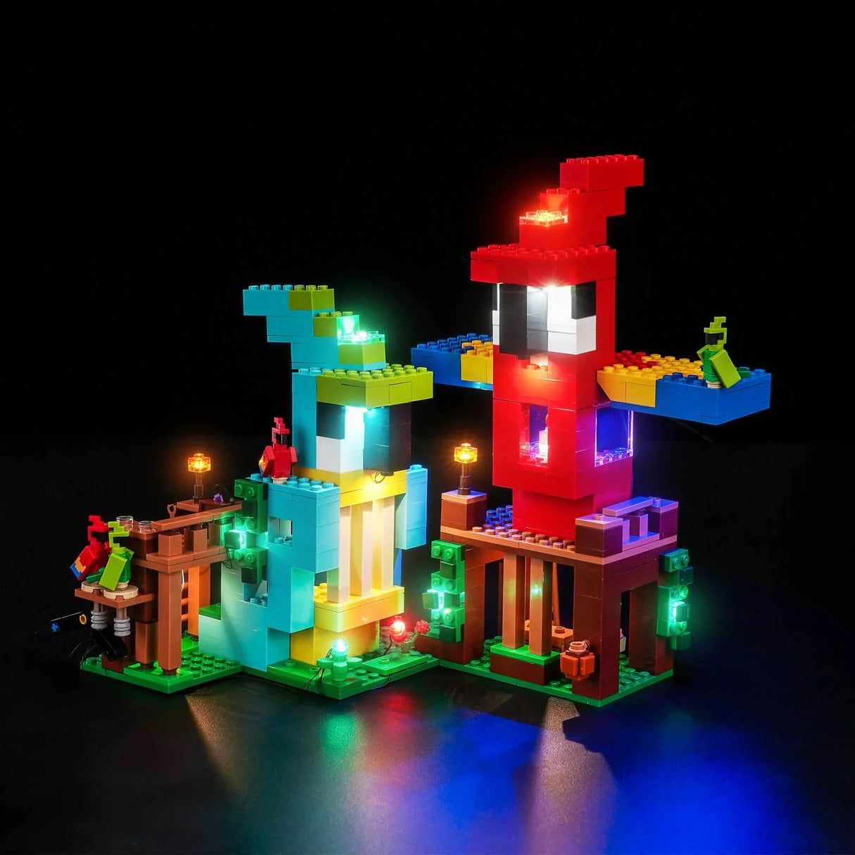 Zwei beleuchtete LEGO-Minecraft-Häuser in Rot und Türkis auf schwarzem Hintergrund