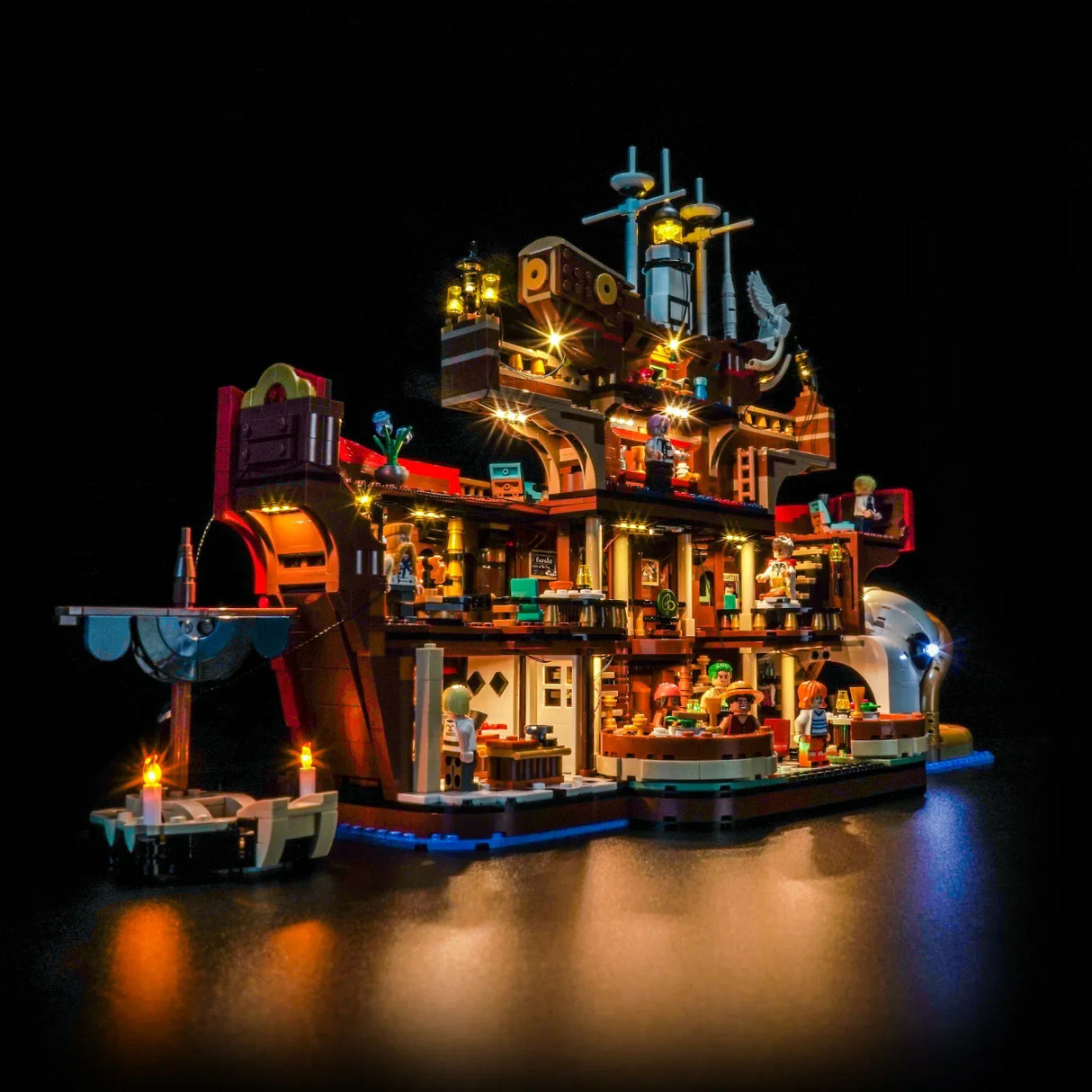 Beleuchtetes LEGO Piratenschiff mit detaillierten Innenräumen und Minifiguren auf schwarzem Hintergrund