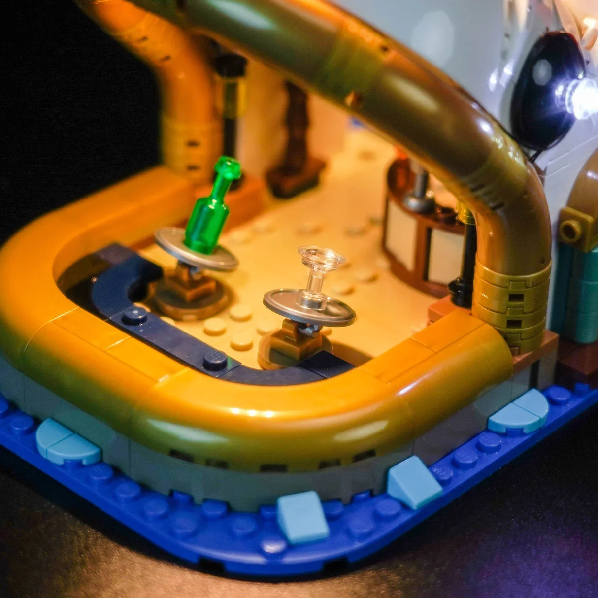 Nahaufnahme eines Lego-Sets mit einer grünen Flasche und einem Glas auf drehbaren Plattformen