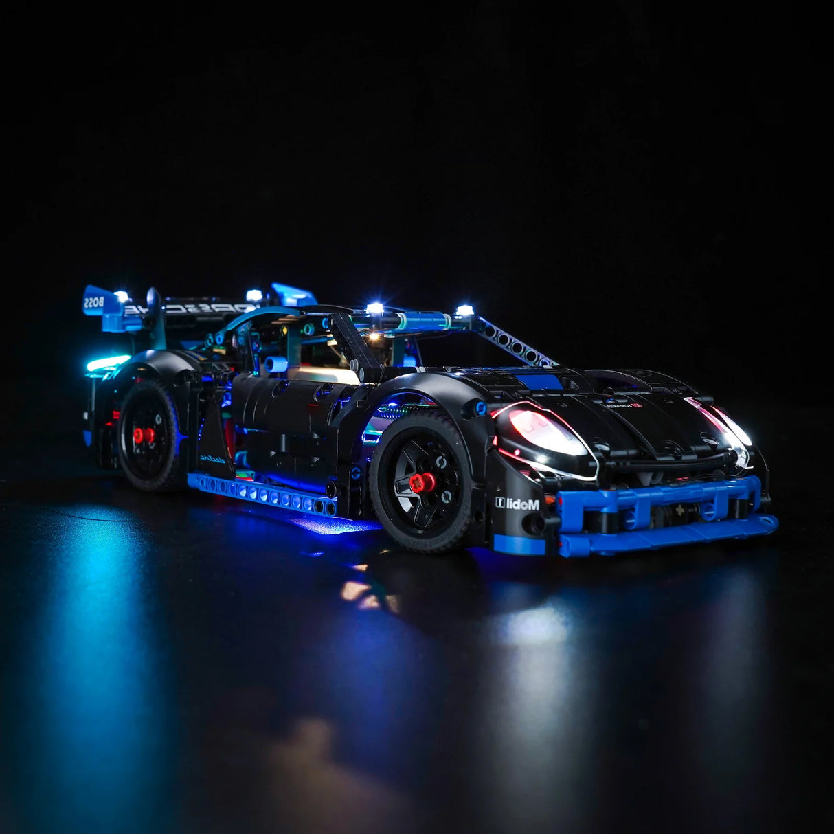 Schwarzes Spielzeugauto mit blauen und weißen Lichtern auf schwarzem Hintergrund