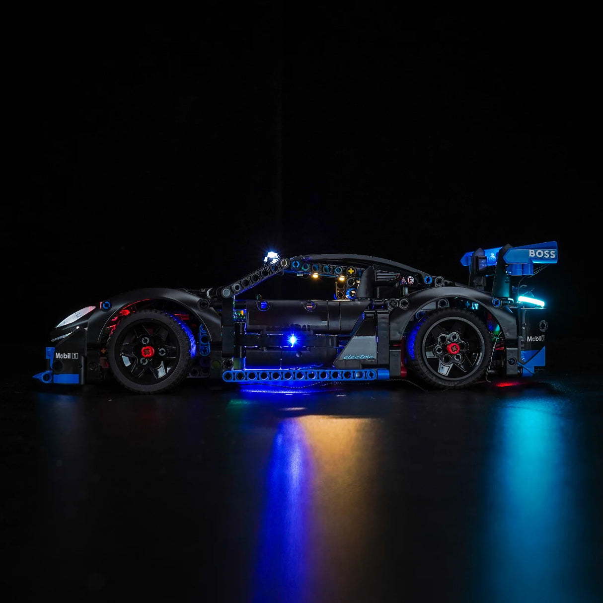 Schwarzes Spielzeugauto mit blauen und roten Lichtern auf schwarzem Hintergrund