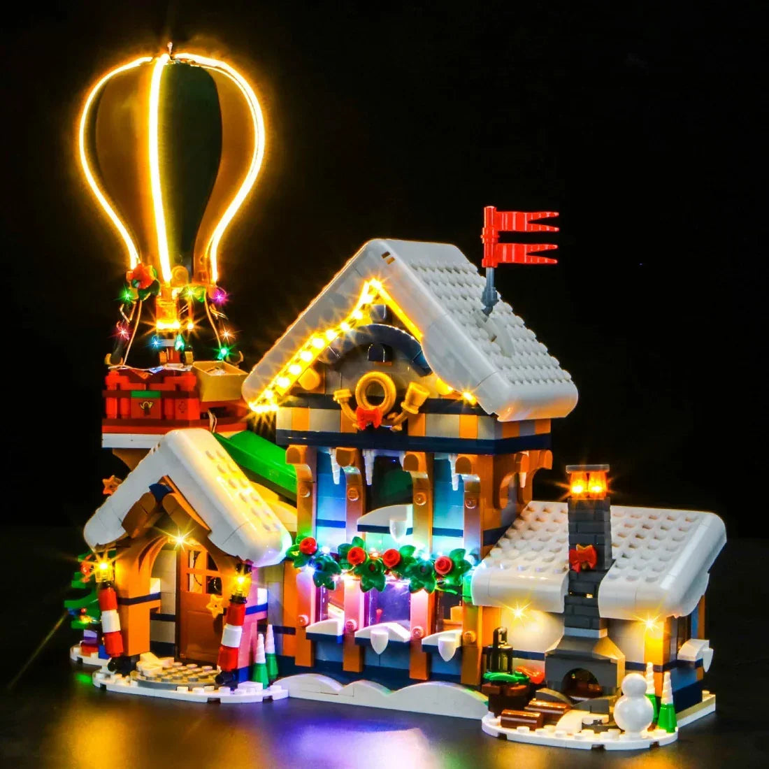 Beleuchtetes Lego Winterdorf Modell mit Heißluftballon vor schwarzem Hintergrund