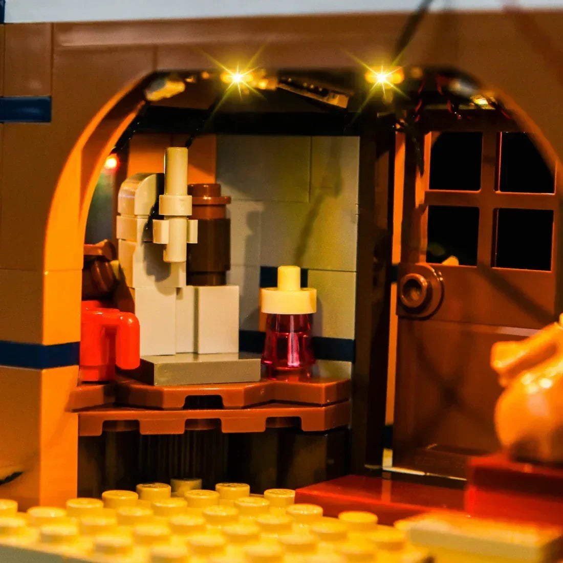Beleuchtetes Interieur eines Lego Gebaeudes mit kleinen Moebeln und Details