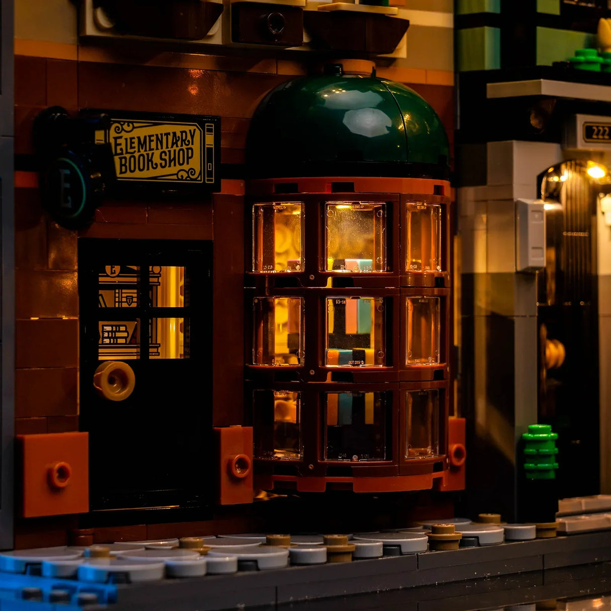 Nahaufnahme eines beleuchteten Lego-Gebäudes mit einem Schild Elementary Book Shop
