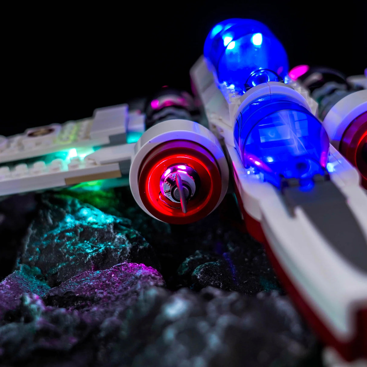 Nahaufnahme eines beleuchteten Lego Star Wars X-Wing Raumschiffs auf einem Felsen