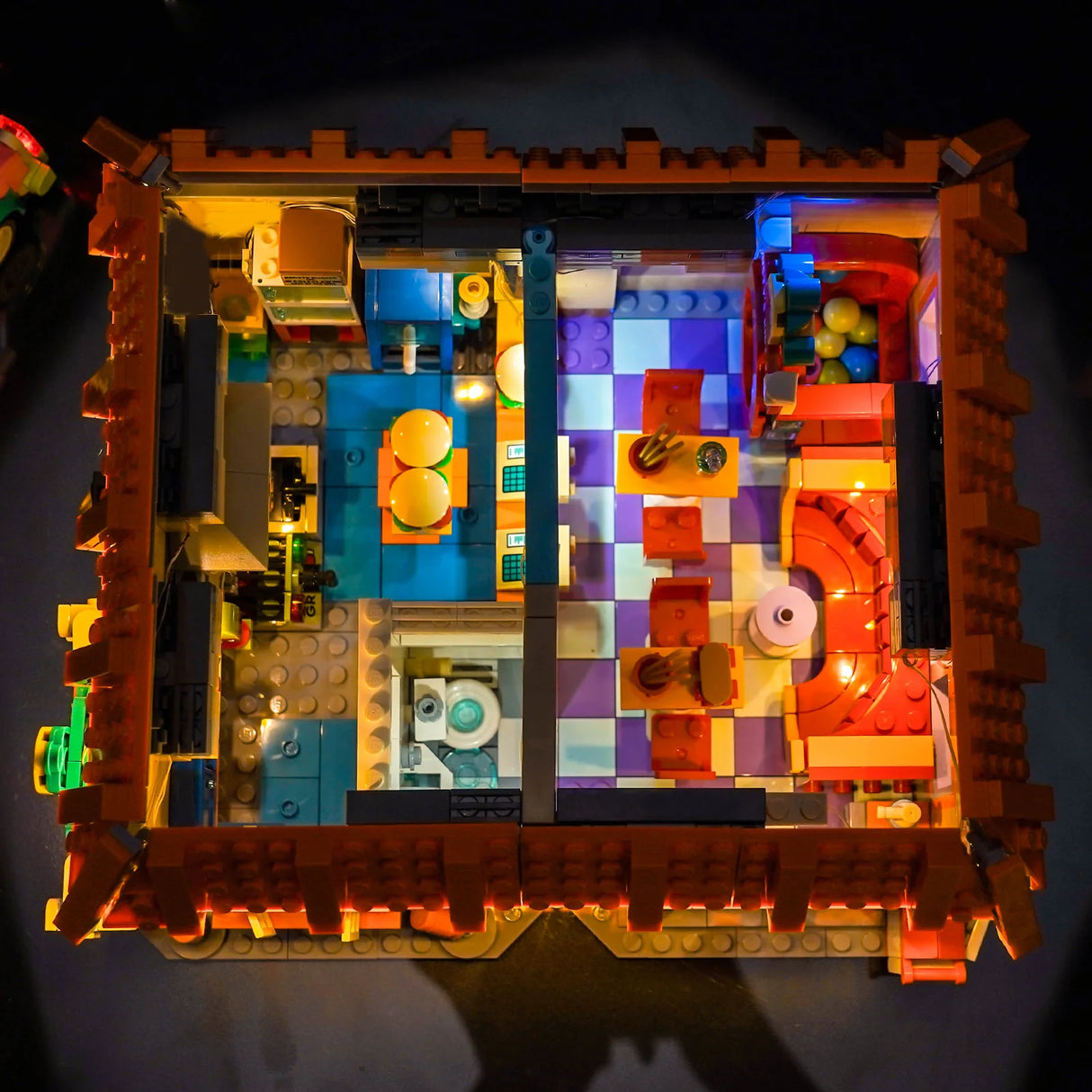 Beleuchtetes Lego-Modell eines Restaurants mit kariertem Boden und Tischen