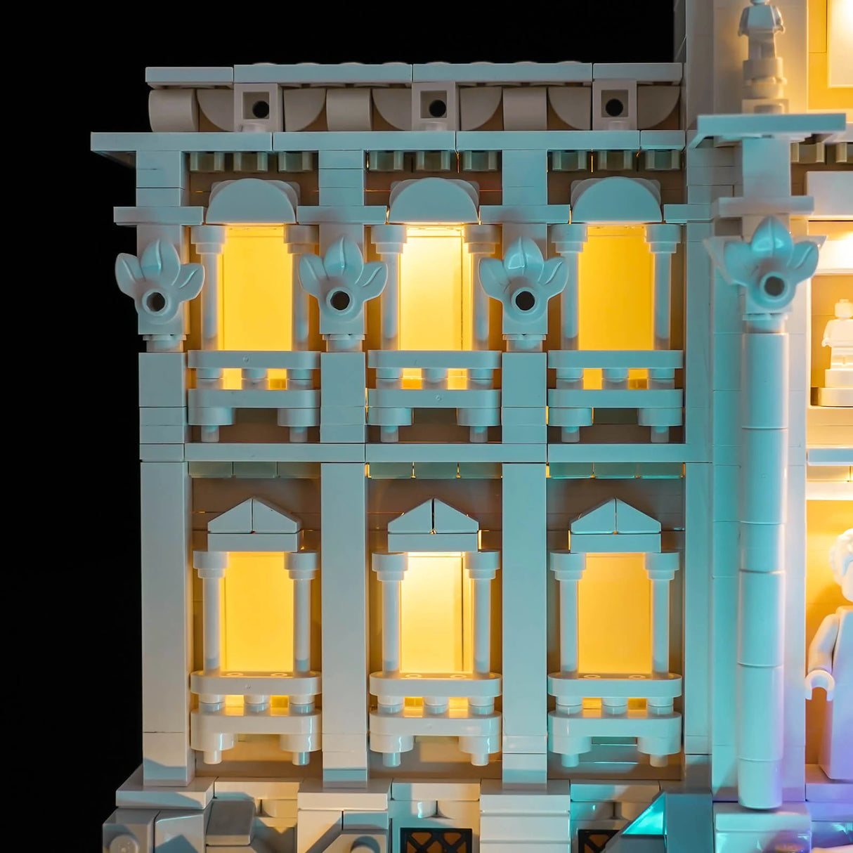 Beleuchtetes LEGO-Gebäude mit gelb leuchtenden Fenstern und blauen Akzenten