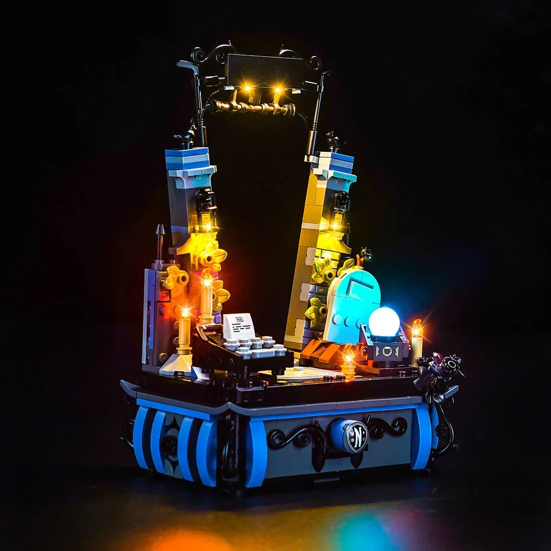 Beleuchtetes Lego Set mit Grabstein und Kristallkugel auf schwarzem Hintergrund