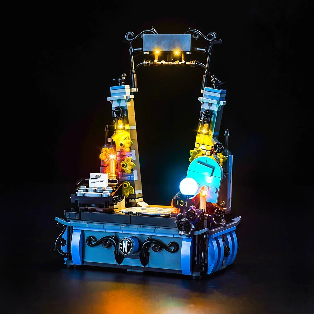 Beleuchtetes Lego Modell eines Schreibtisches mit Schreibmaschine und Kristallkugel vor schwarzem Hintergrund