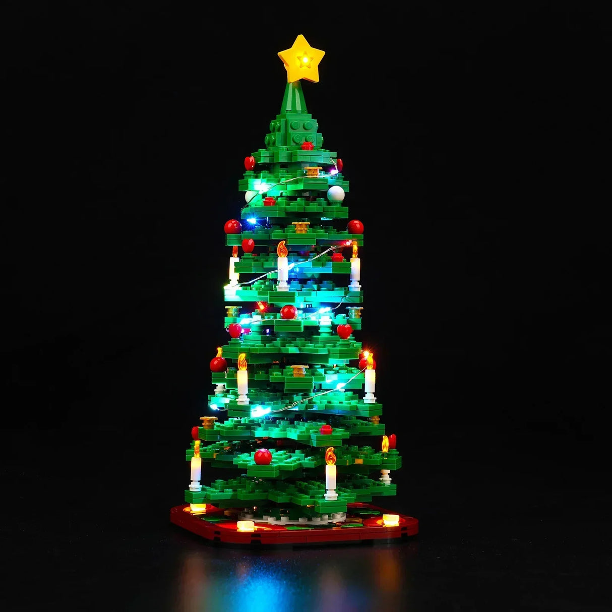 Weihnachtsbaum aus Klemmbausteinen mit LED Beleuchtung und Sternspitze vor schwarzem Hintergrund