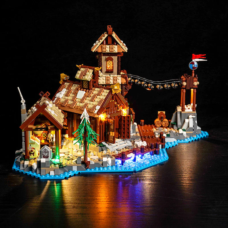 Beleuchtetes LEGO Wikingerdorf mit Häusern, Brücke und Flagge am Wasser