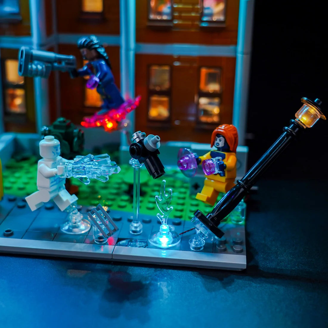Lego Ghostbusters Figuren mit leuchtenden Waffen und Geistern vor einem Gebäude