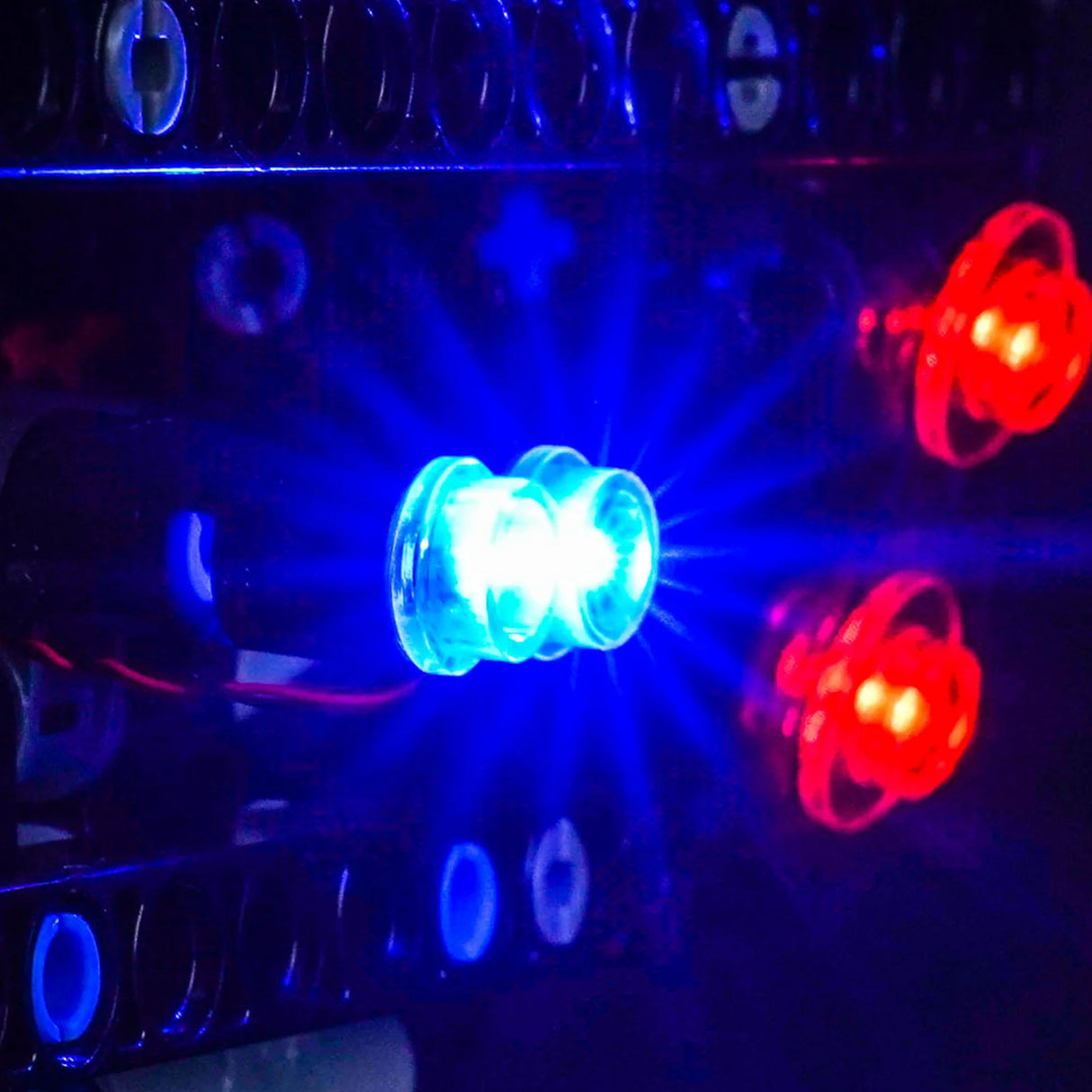 Nahaufnahme von blauen und roten LEDs, die in einem dunklen Raum leuchten