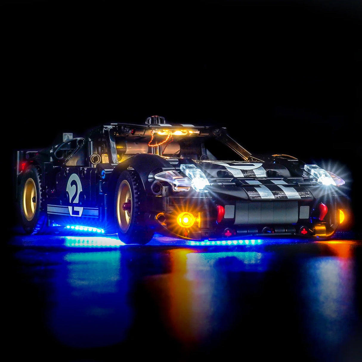 Ein schwarzes Lego-Rennauto mit der Nummer 2, beleuchtet von blauen, weißen und gelben Lichtern