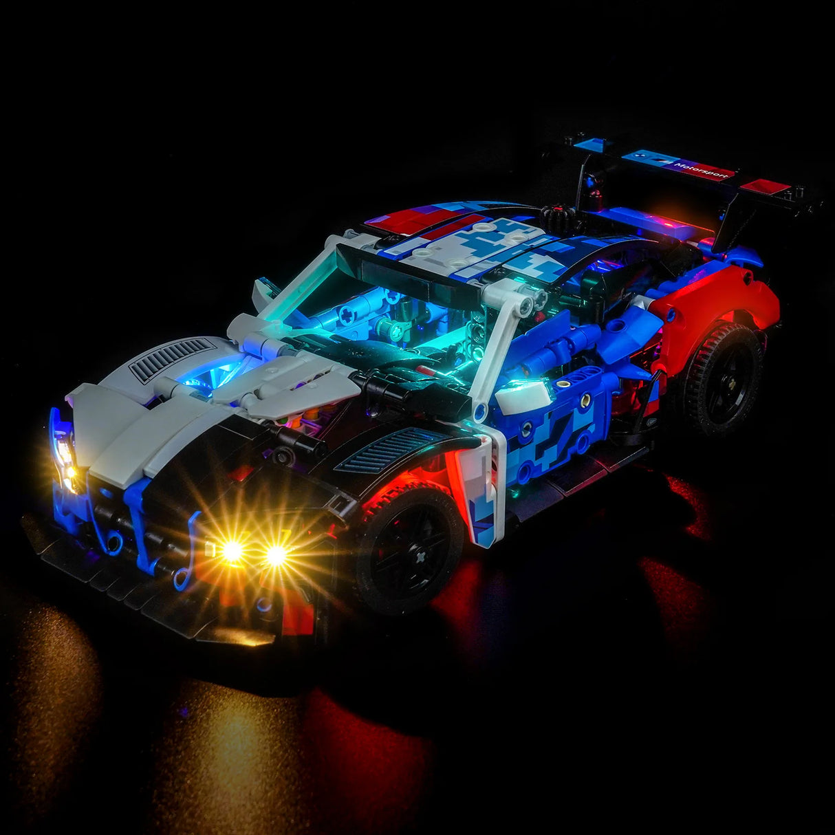 Beleuchtetes LEGO Technic BMW M4 GT3 Modellauto in Blau, Rot und Weiß auf schwarzem Hintergrund