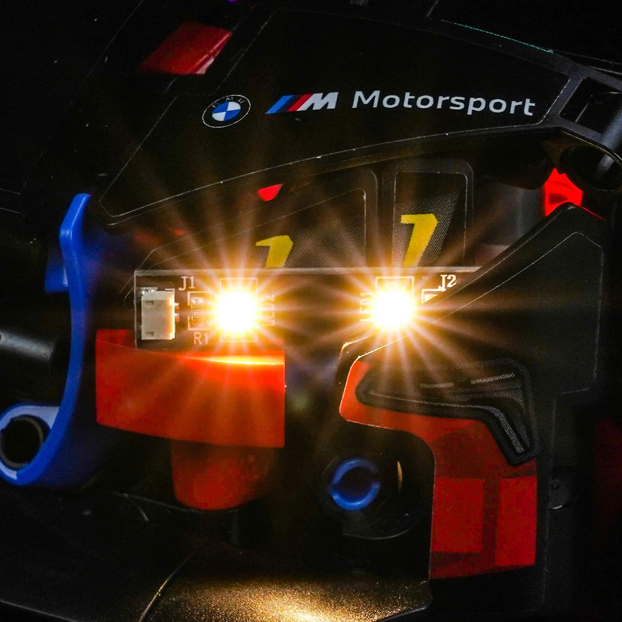 Nahaufnahme der leuchtenden Scheinwerfer eines BMW M Motorsport Spielzeugautos