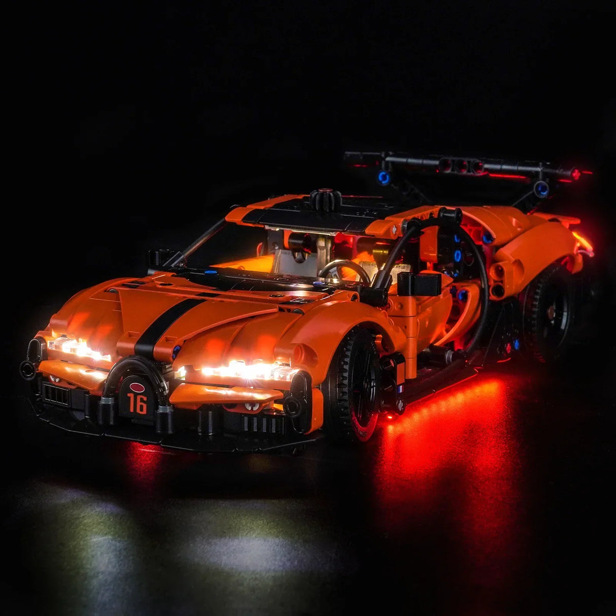 Orangefarbenes Spielzeugauto mit schwarzen Streifen und leuchtenden Lichtern