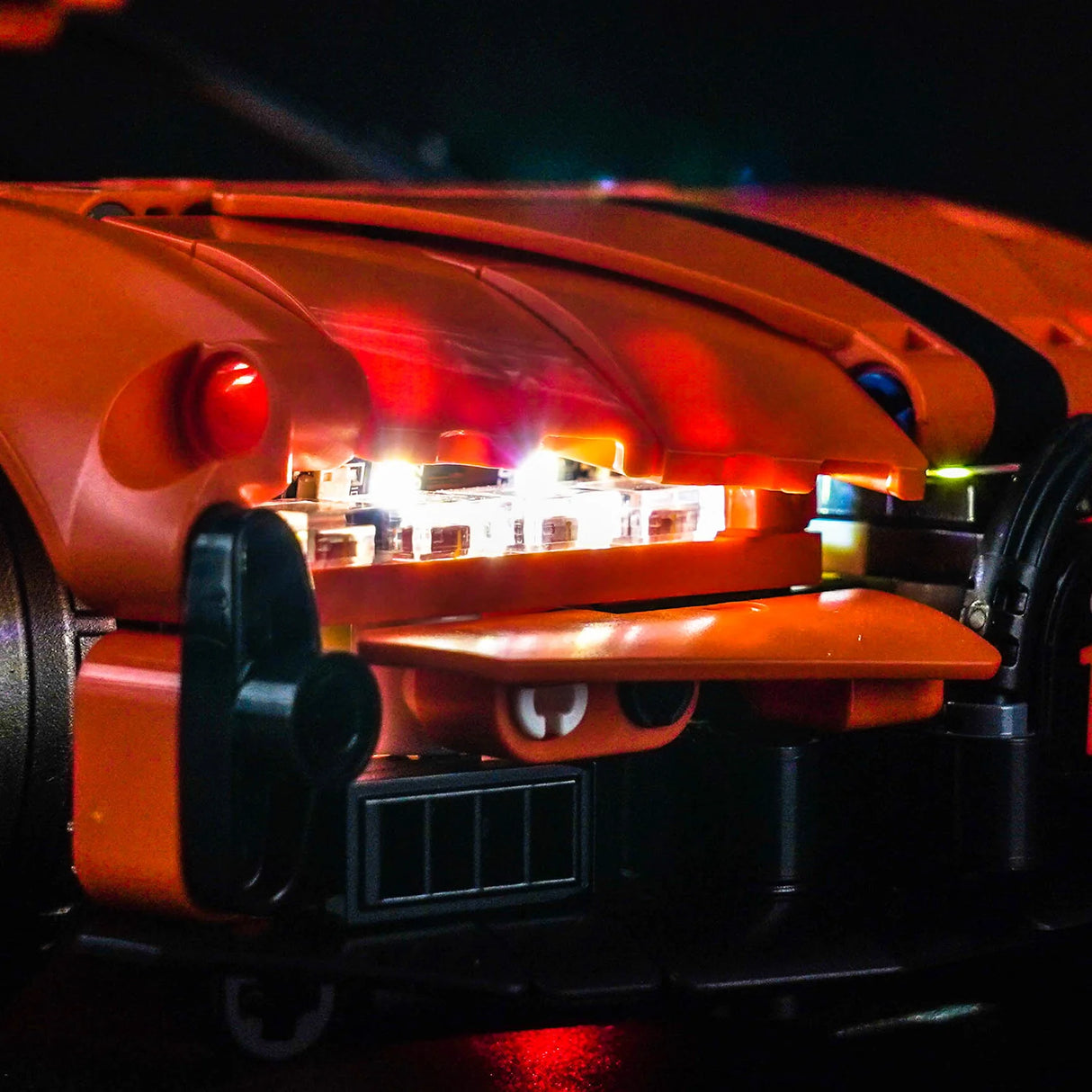 Nahaufnahme eines orangefarbenen Spielzeugautos mit leuchtenden Lichtern