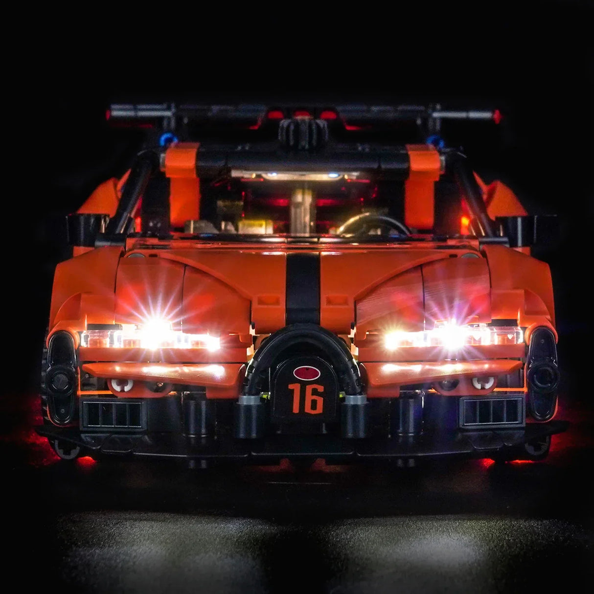 Orangefarbenes Spielzeugauto mit leuchtenden Scheinwerfern und der Nummer 16 auf der Vorderseite