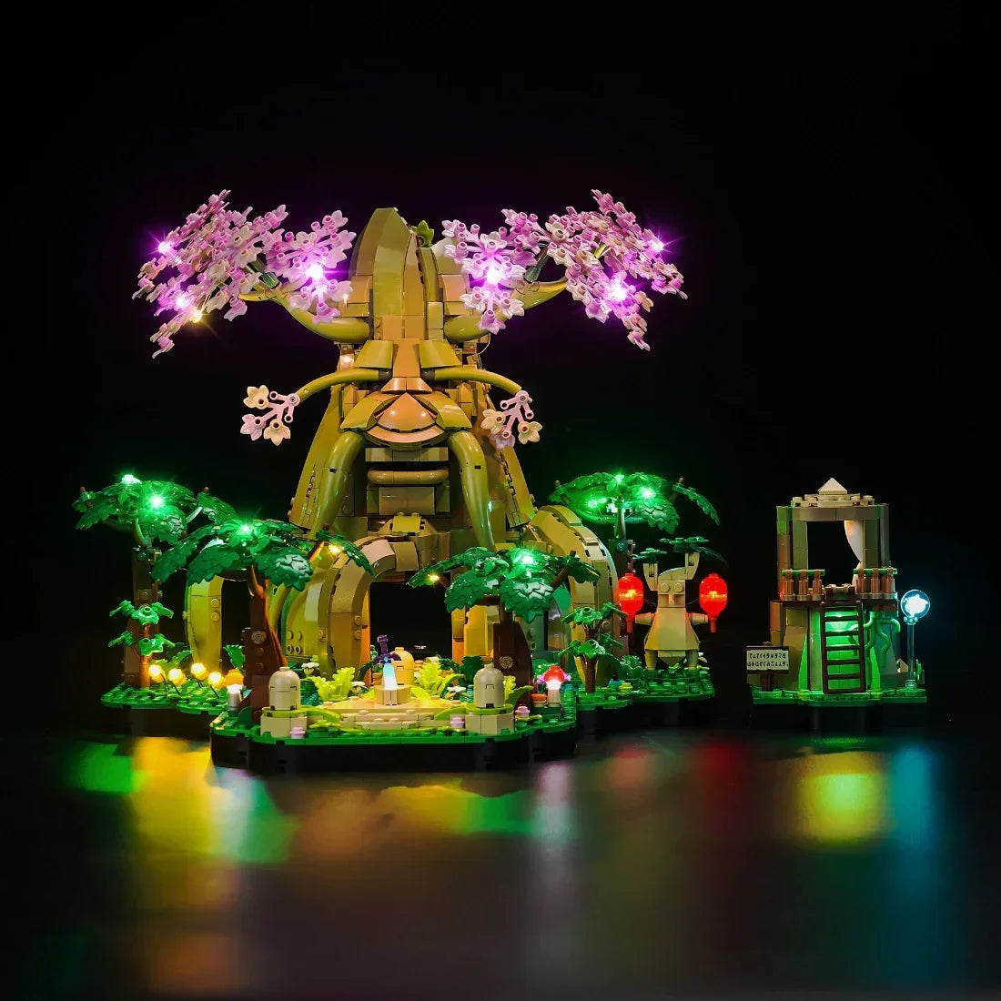 Beleuchtetes Lego Set mit einem grossen Baum und einer kleinen Struktur vor schwarzem Hintergrund