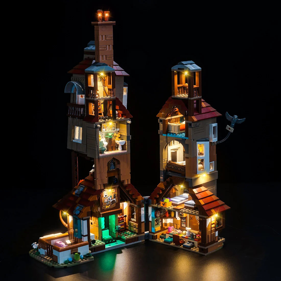 Beleuchtetes Lego Harry Potter Haus mit mehreren Etagen und einer Eule vor schwarzem Hintergrund