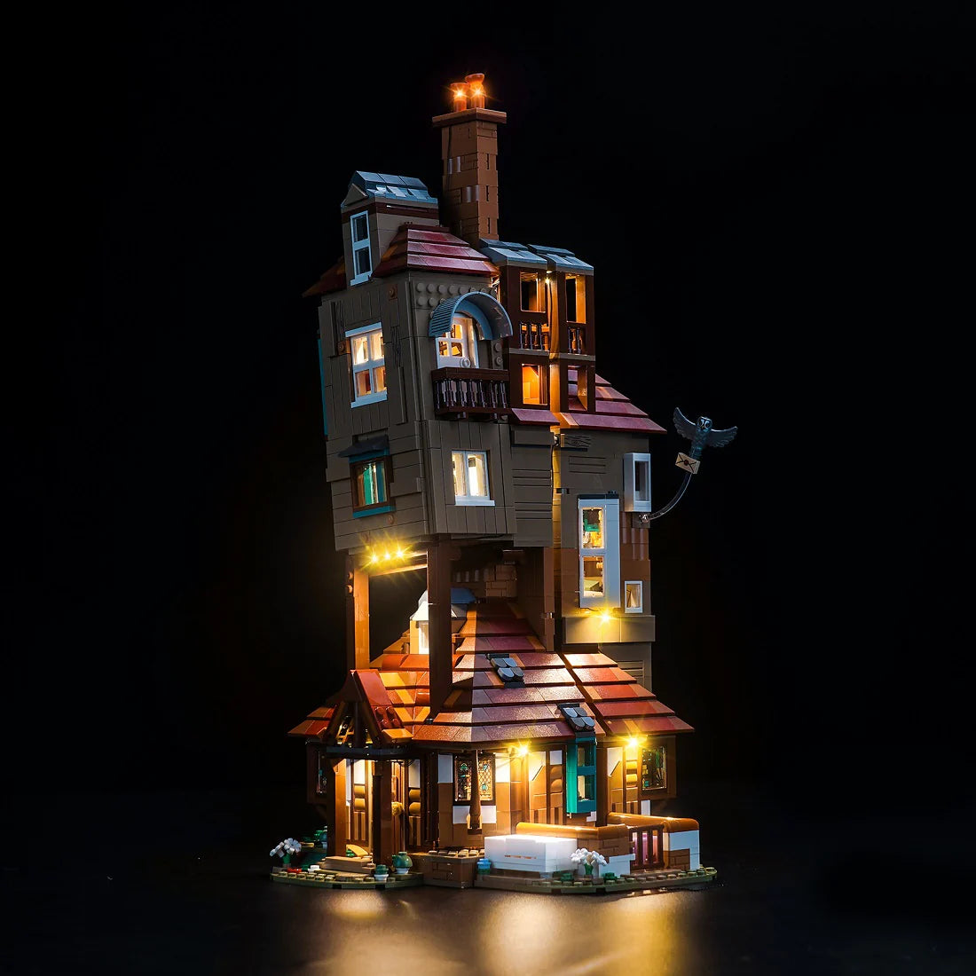 Beleuchtetes Lego Modell des Fuchsbau Hauses aus Harry Potter vor schwarzem Hintergrund