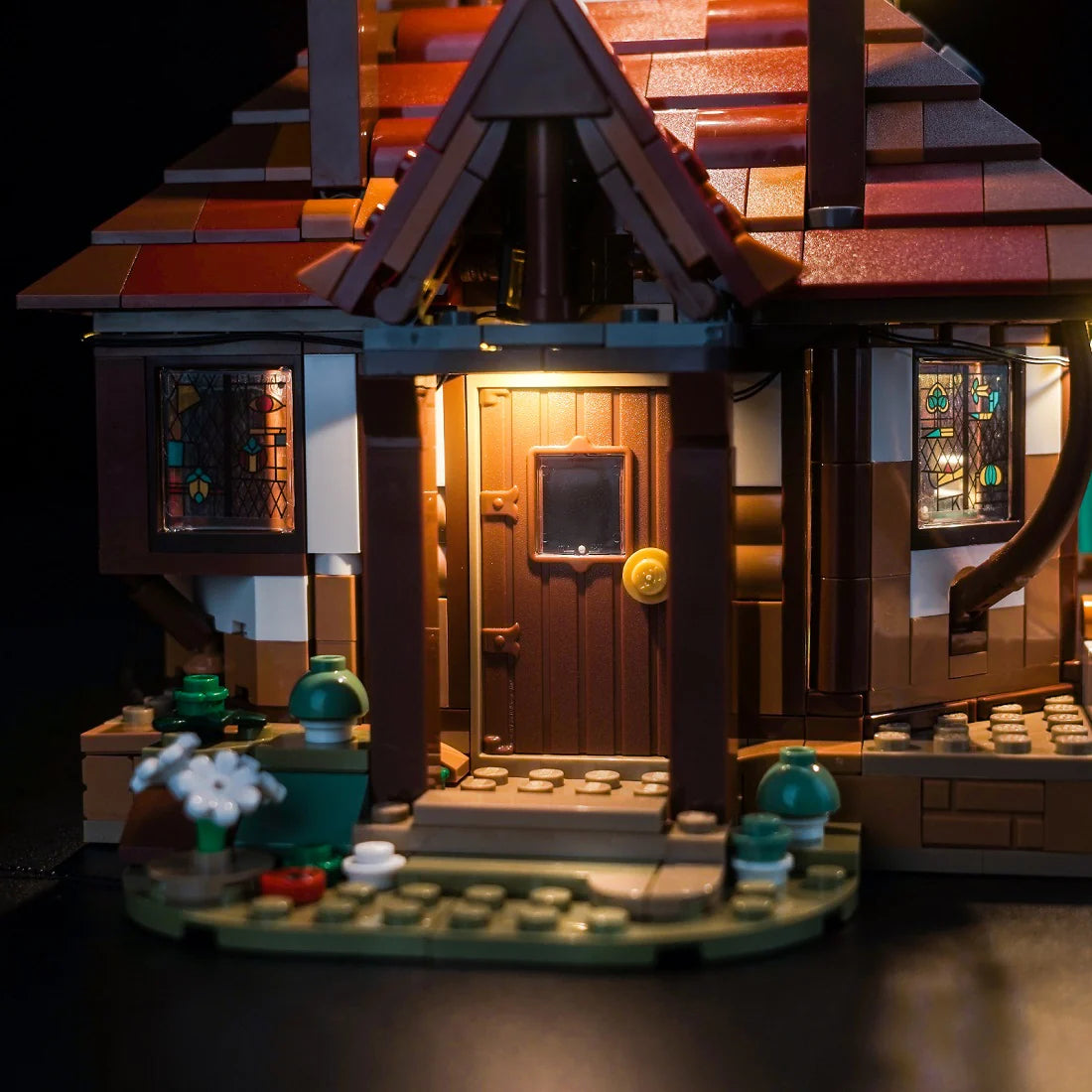 Beleuchtetes Lego Haus mit brauner Tür und Buntglasfenstern