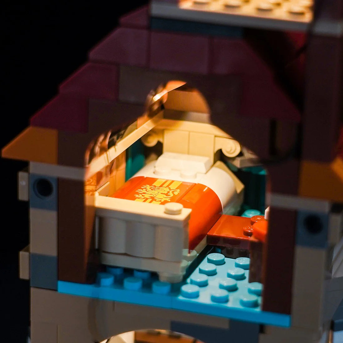 Beleuchtetes Schlafzimmer in einem Lego Modell mit einem Bett und einer Decke mit Löwenwappen
