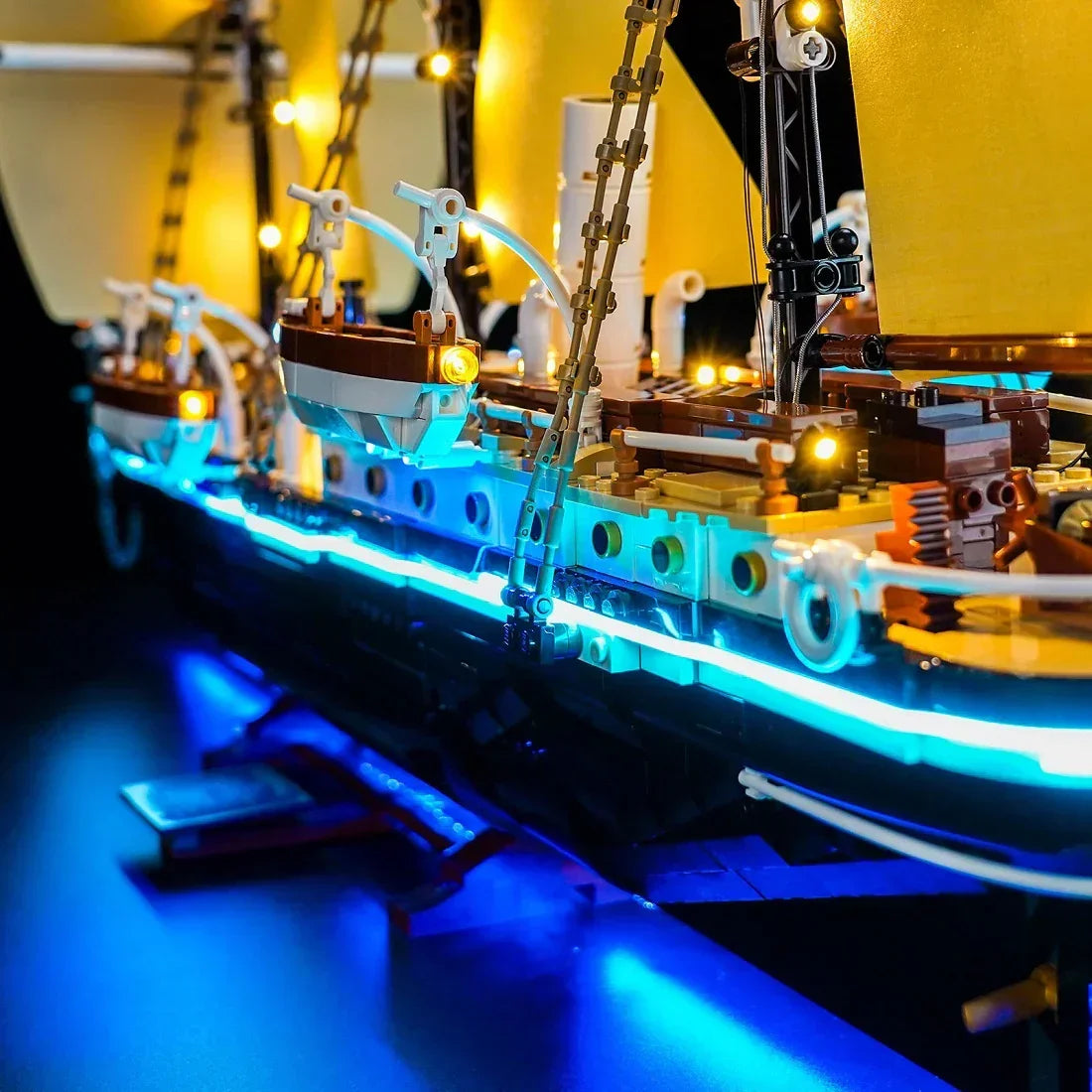 Beleuchtetes Lego-Schiff mit gelben Segeln und blauen Lichtern am Rumpf