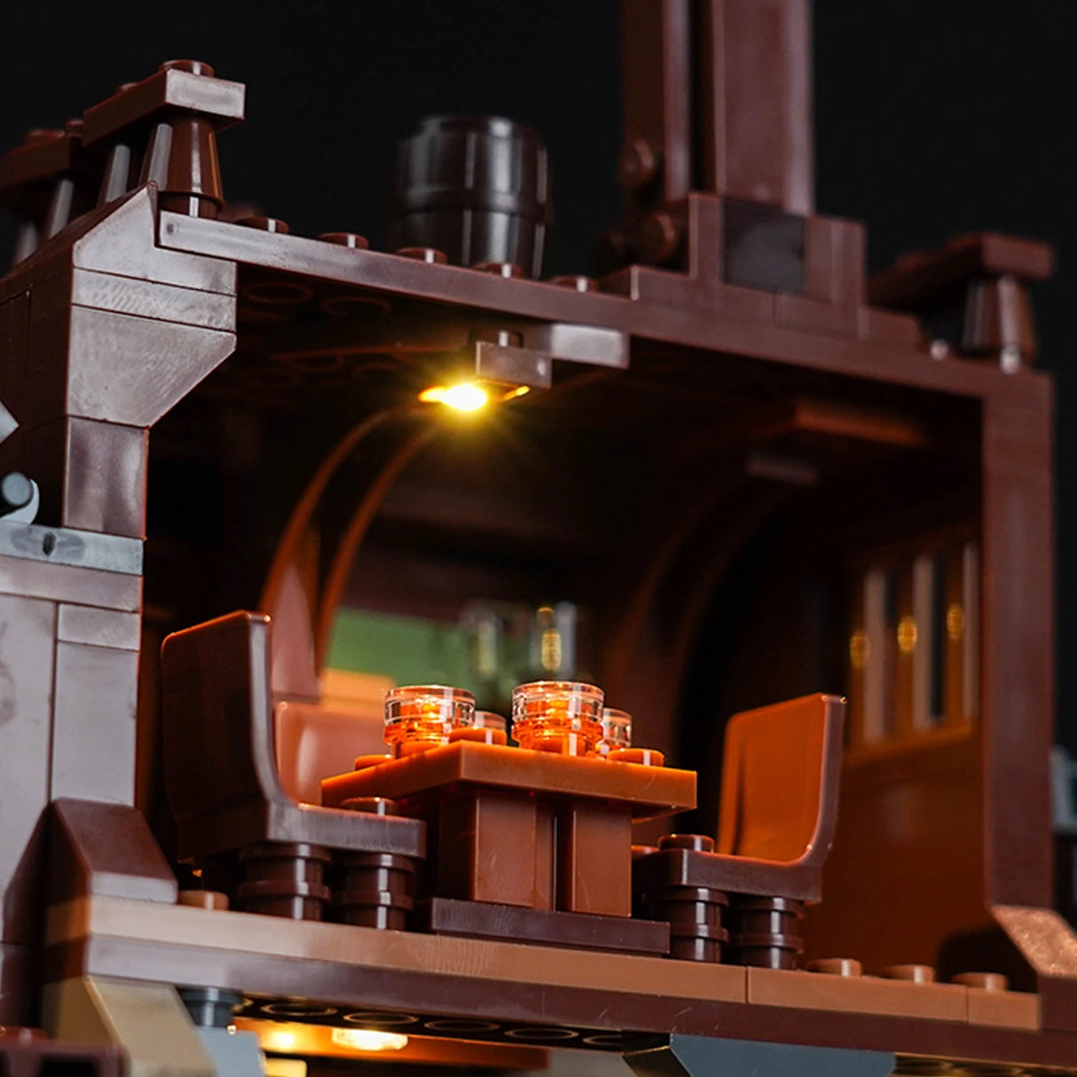 Nahaufnahme eines beleuchteten Lego-Modells mit einem Tisch und Stühlen
