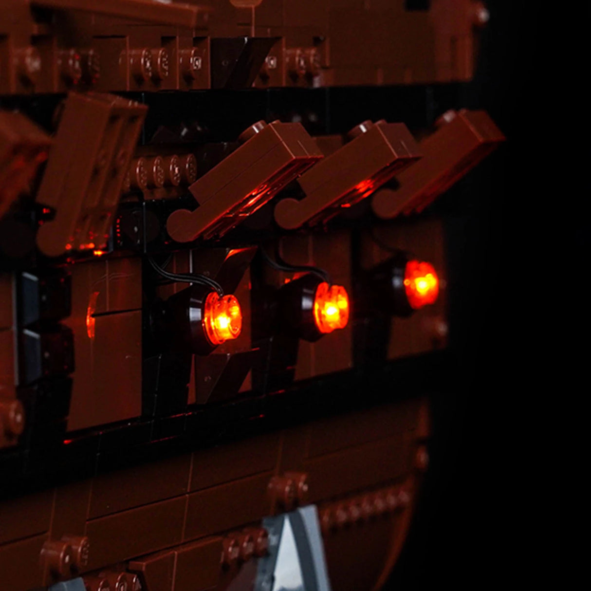 Nahaufnahme von drei leuchtenden roten Lichtern an der Seite eines braunen Lego-Modells