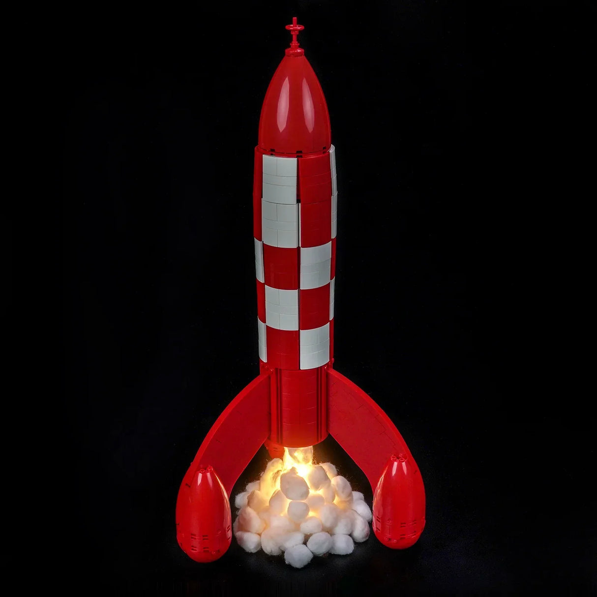 Rote und weiße Rakete mit Flammen und Rauch am Boden