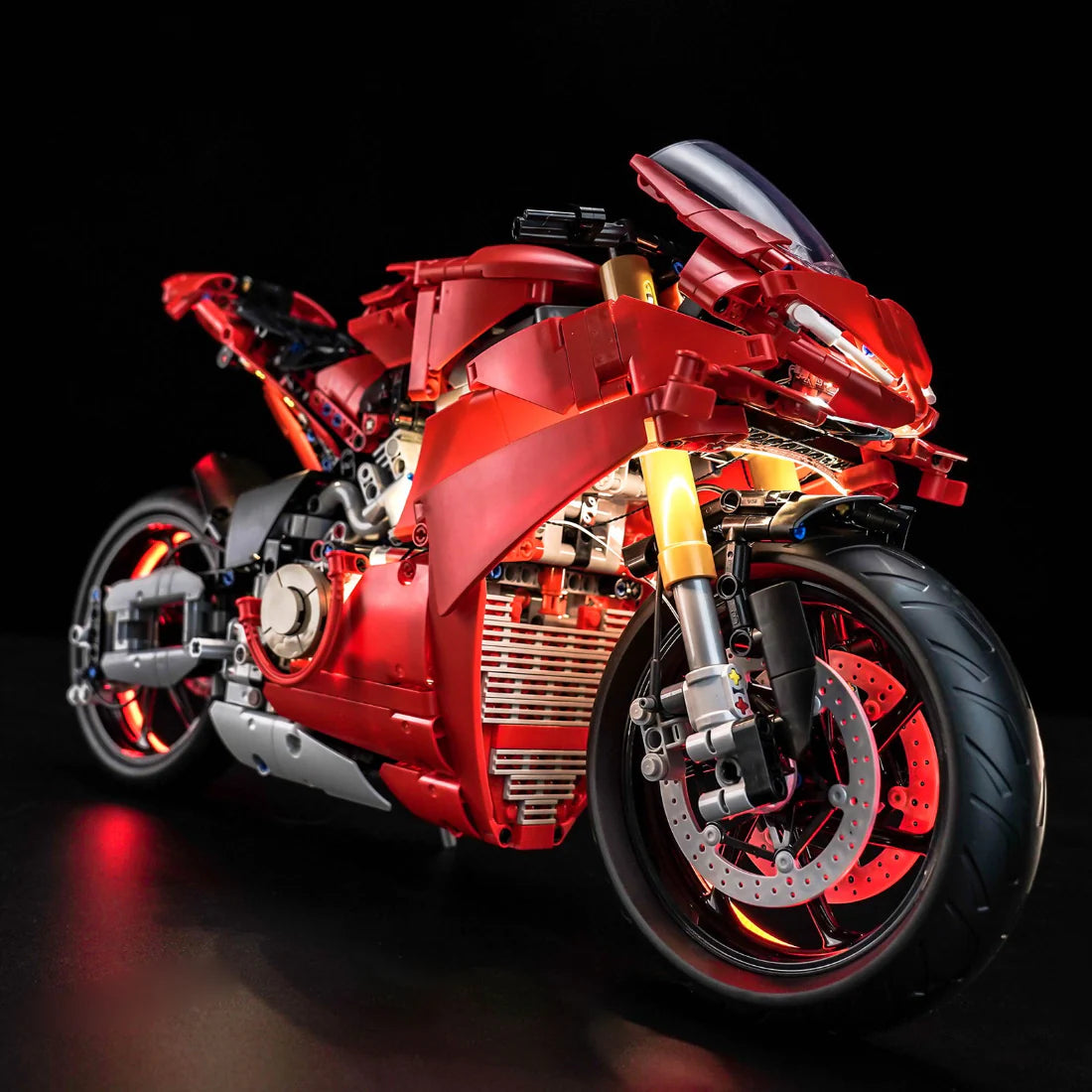 Rotes Spielzeugmotorrad mit leuchtenden Lichtern auf schwarzem Hintergrund