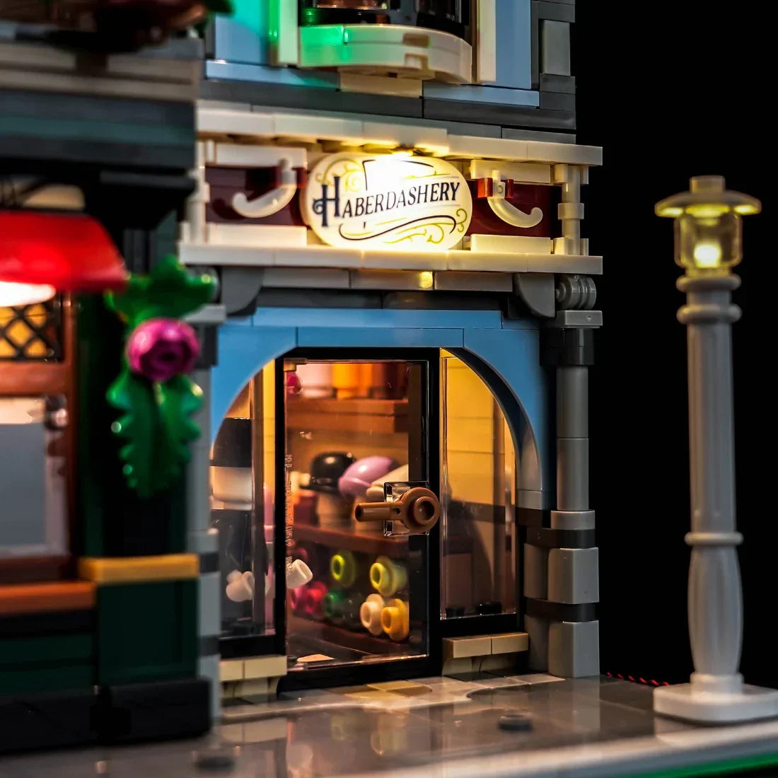 Nahaufnahme eines beleuchteten Lego-Gebäudes mit einem Schild Haberdashery und einer Straßenlaterne