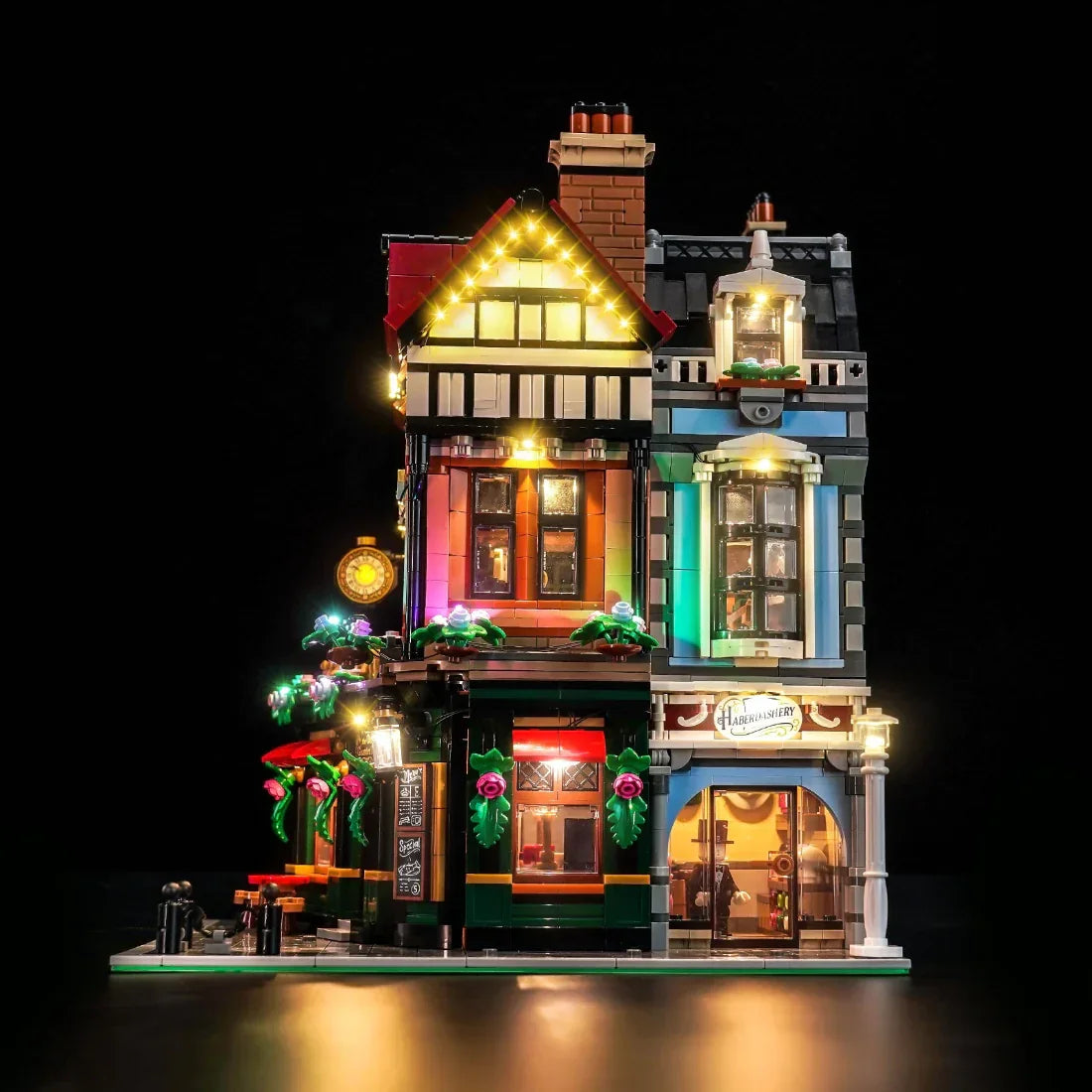 Beleuchtetes Lego-Gebäude mit zwei Geschäften und Wohnungen darüber
