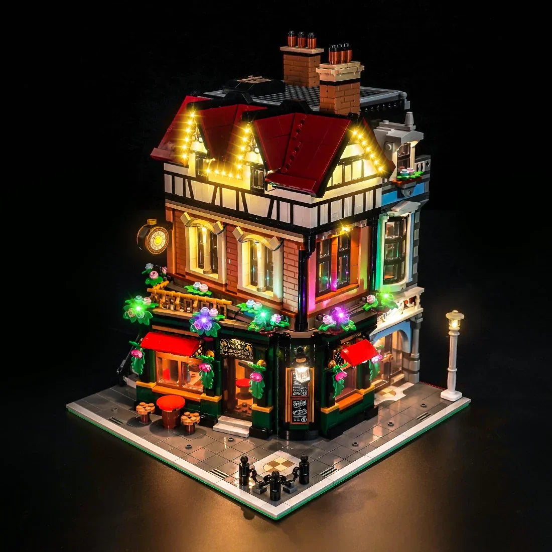 Beleuchtetes LEGO-Modell eines Gasthauses mit roten Dächern und Blumenkästen