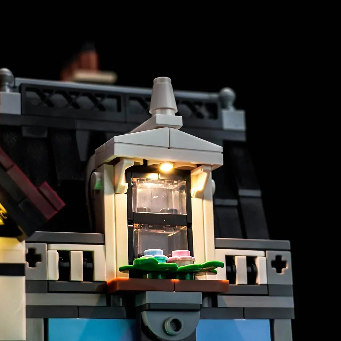 Beleuchtetes Fenster eines LEGO Hauses mit Blumenkasten