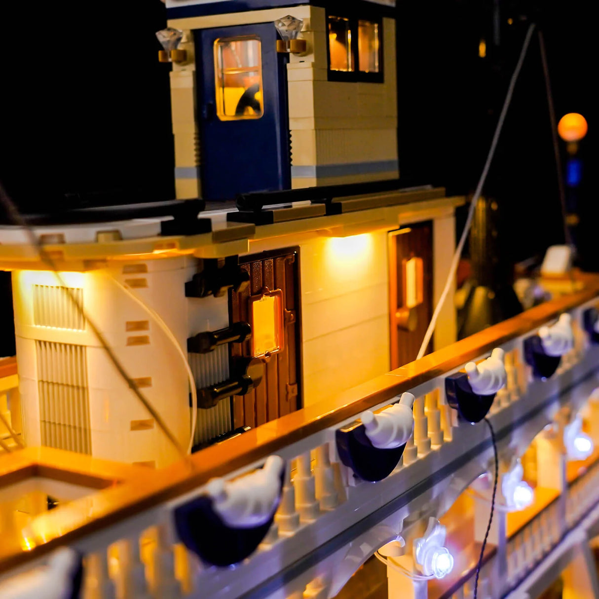Nahaufnahme eines beleuchteten LEGO-Schiffs mit blauen und weißen Details bei Nacht