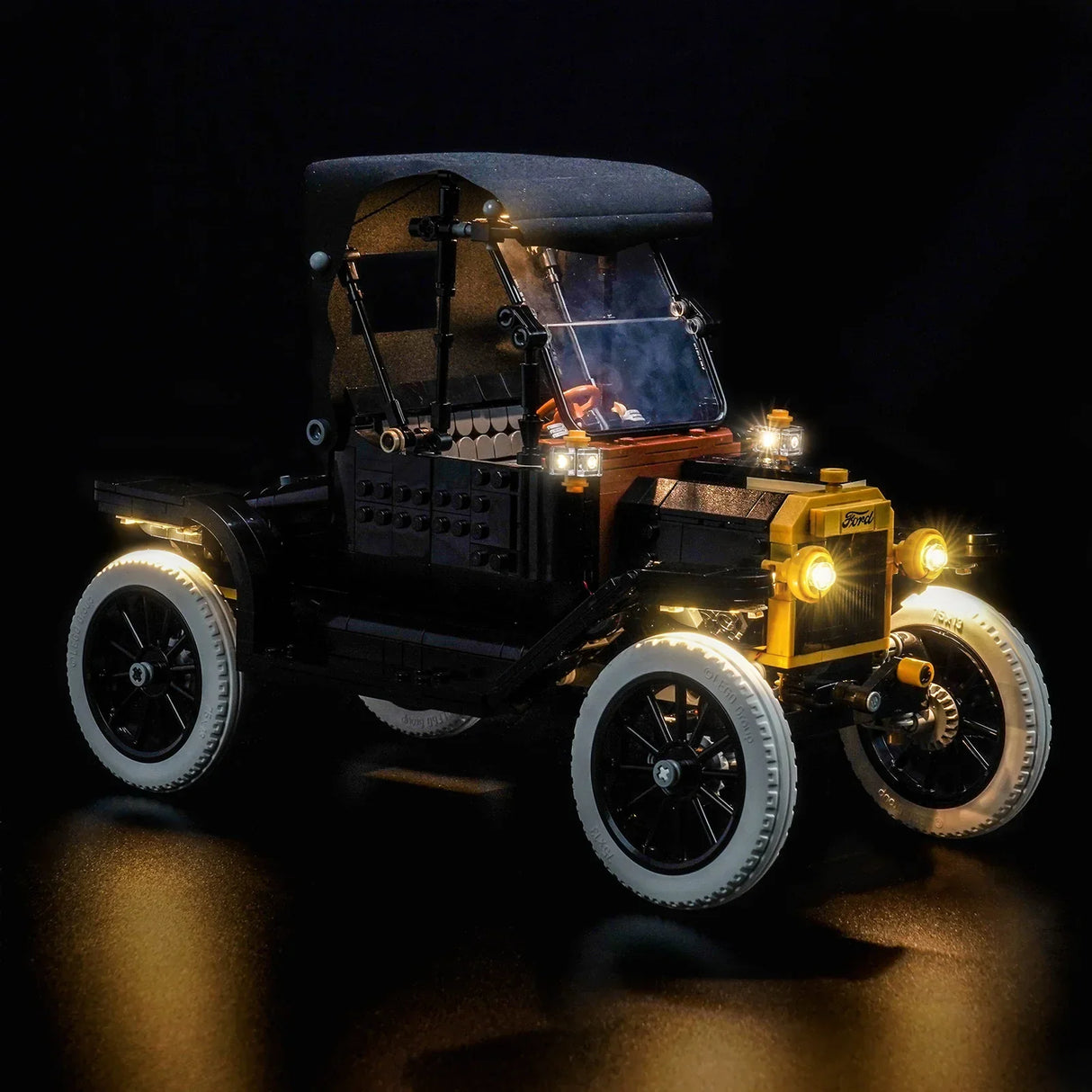 Beleuchtetes Lego Ford Modell T Auto mit gelben Scheinwerfern und weißen Reifen auf schwarzem Hintergrund