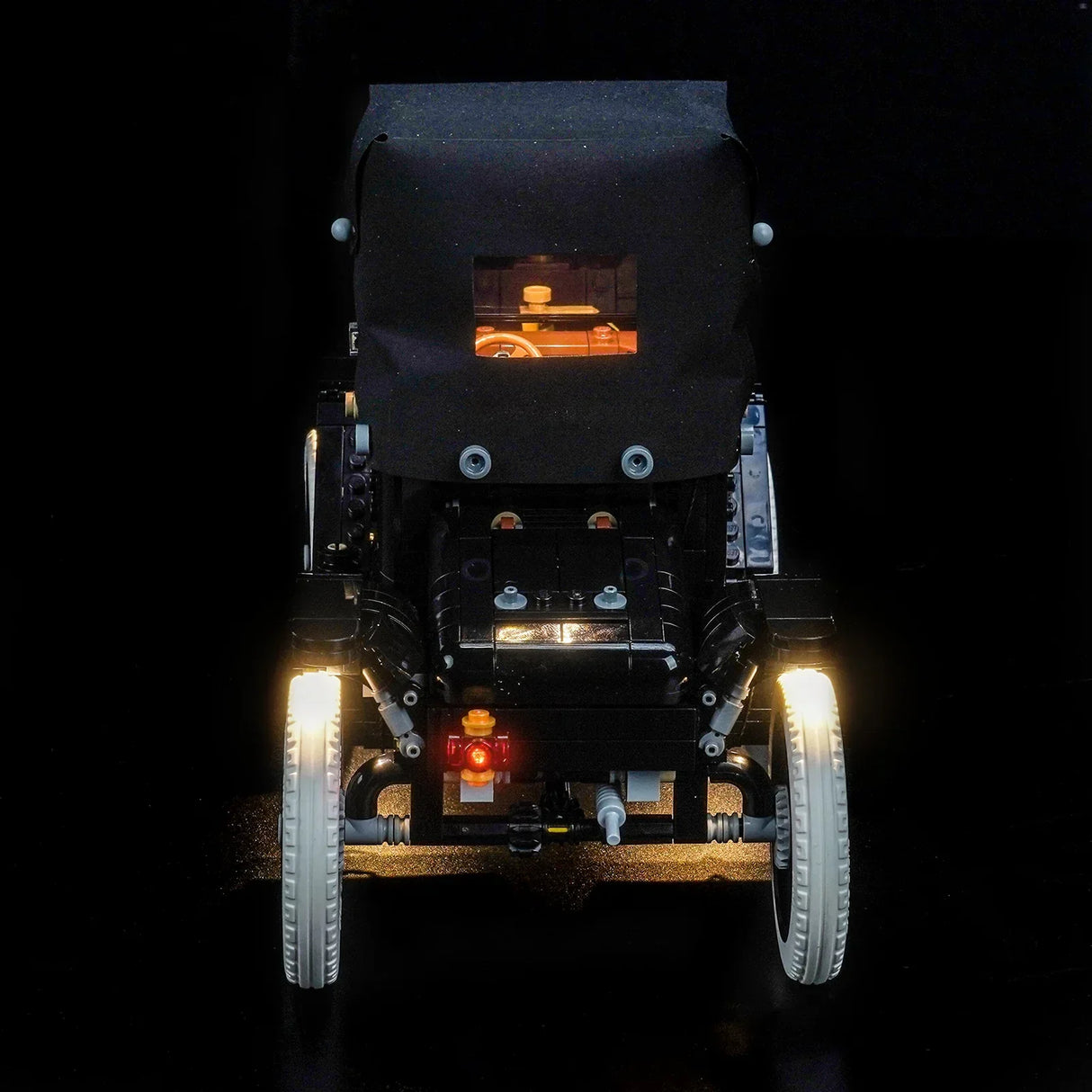 Rückansicht eines schwarzen Lego-Autos mit leuchtenden Scheinwerfern und Rücklichtern
